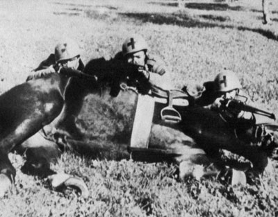 Savoia troopers take up position behind a prone horse.