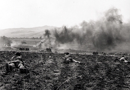 Canadians take up firing positions in a ploughed field