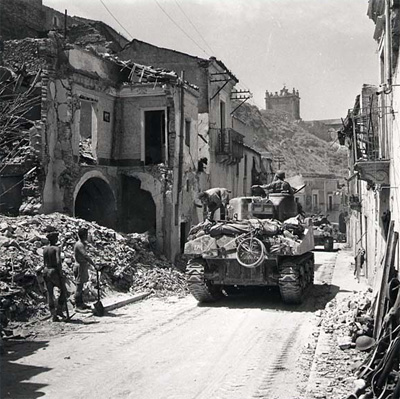 Canadian Shermans advance through a Sicilian town.