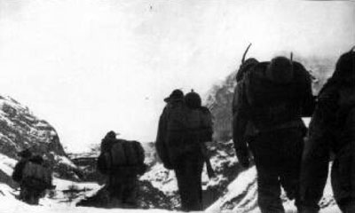 A line of Monterosa Alpini marching on the snow-covered mountains.