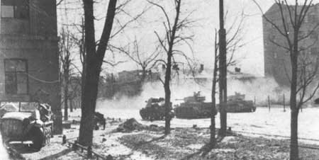 Two Panzer IVs and a Marder hammer away at some Soviet occupied buildings