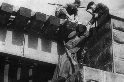 Partisans in mix clothing set charges on a bridge