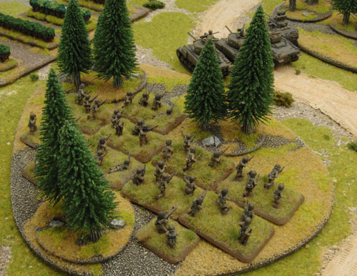 The American infantry and tanks take cover in the woods