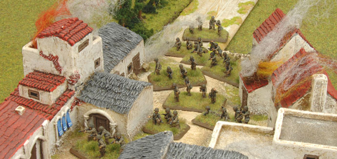 The Rifle platoon enters the village taking cover from the artillery fire.