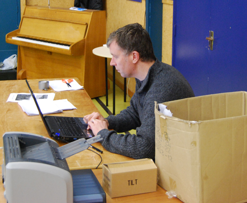 Phil stares intently at the laptop