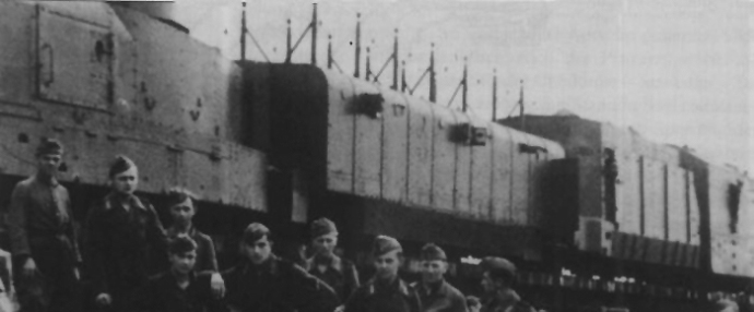 The crew of German Armoured Train No. 21 stand before an artillery car, assault car and locomotive