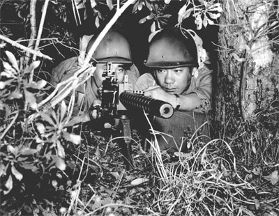 Nisei man a .30cal Machine-gun during woodland training