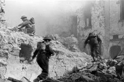 British troops advance through the rubble of Cassino town.