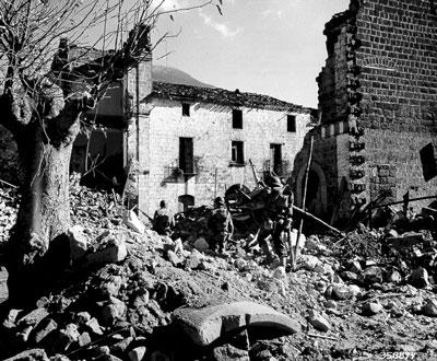 US Riflemen move through a bomb damaged town in southern Italy.