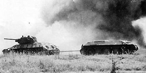 A TT-34 tows a disabled T-34 from the field during Kursk