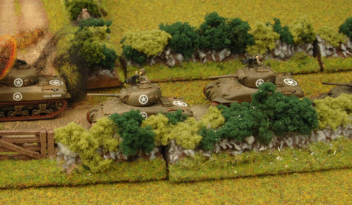 Tanks move pass their comrade's wrecks Tanks move pass their comrade's wrecks