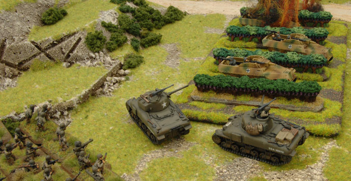The Shermans flank the Sd Kfz 251/9s
