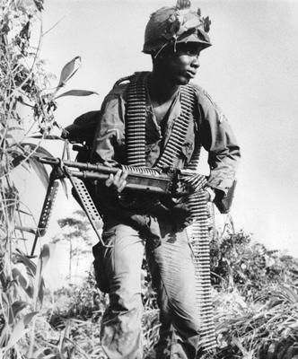 An American soldier move through the undergrowth with his M60